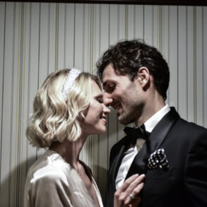 Couple smiling intimately in formal attire.