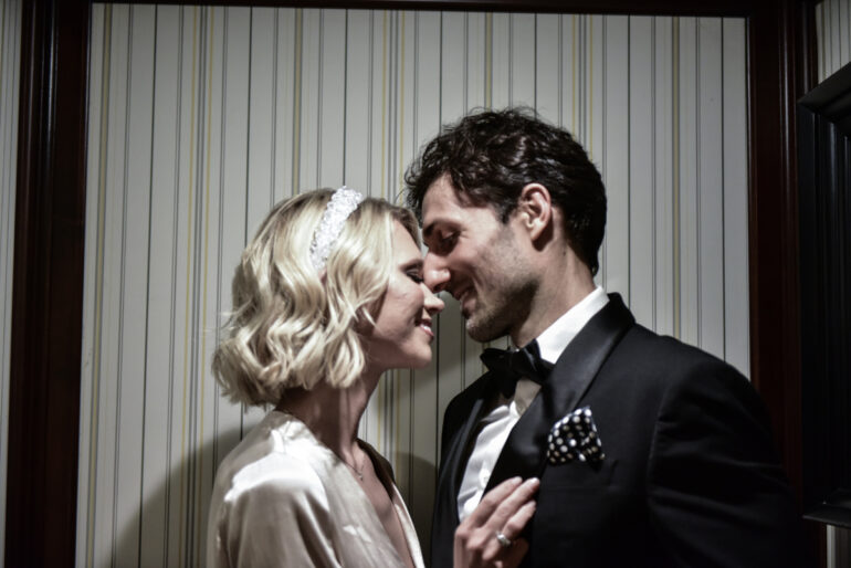 Couple smiling intimately in formal attire.