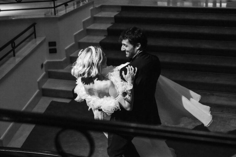 Bride and groom dancing in elegant setting.