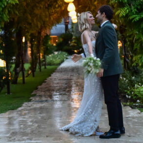 Couple embracing on garden path at dusk.