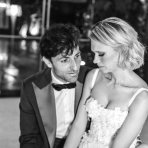 Couple sitting closely together in formal wear.