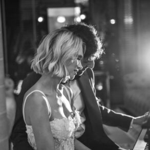 Couple playing piano in dimly lit room