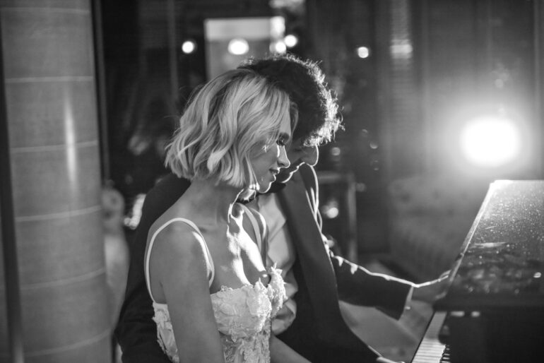 Couple playing piano in dimly lit room