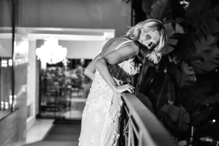 Woman in elegant dress smiling on balcony
