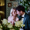 Couple holding hands, smiling at dinner table.