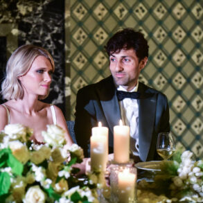 Couple at candlelit dinner, floral centrepiece visible.