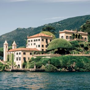 A large white building sitting on top of a lush green hillside