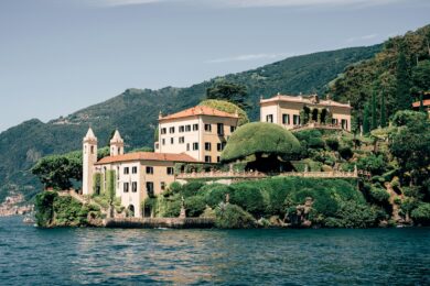 A large white building sitting on top of a lush green hillside