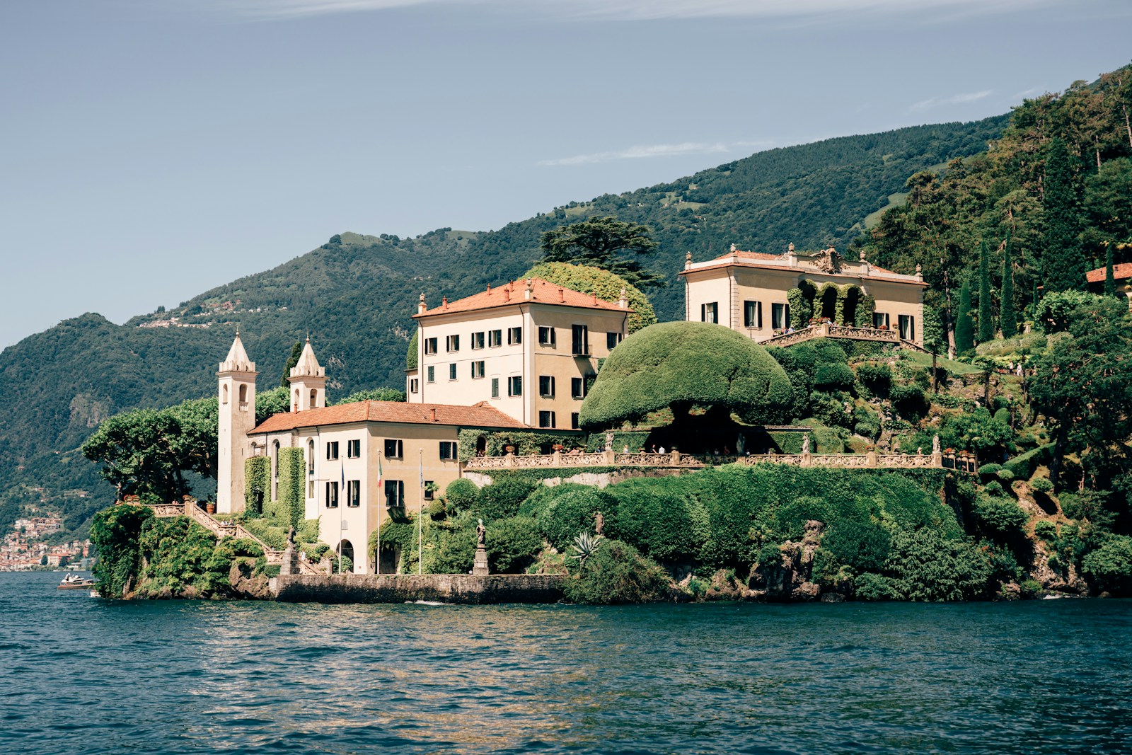 A large white building sitting on top of a lush green hillside