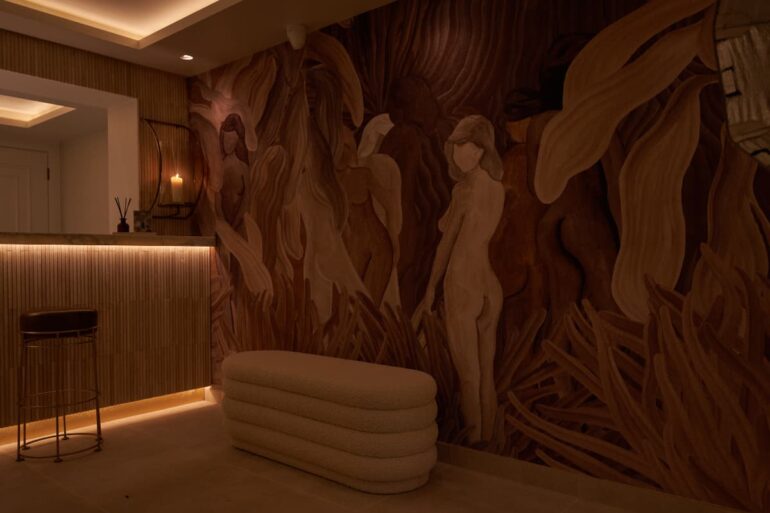 Dimly lit room with abstract mural artwork.
