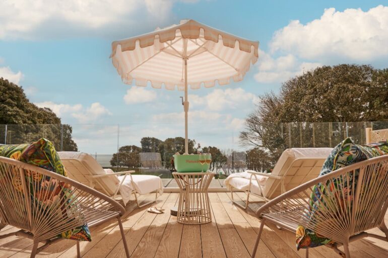 Sunny patio with loungers and a parasol.