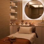 Cosy spa massage room with candles and towels.