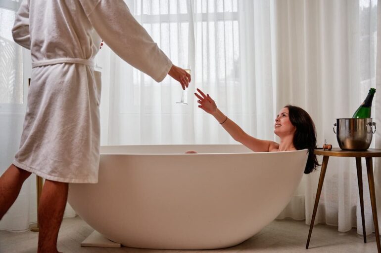 Couple enjoying champagne in a luxurious bathtub.