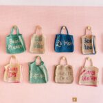 Colourful beach bags hanging on wall display.
