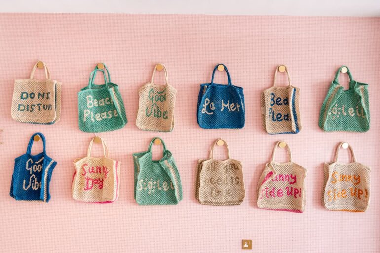Colourful beach bags hanging on wall display.