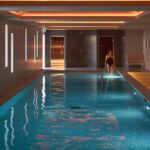 Indoor pool with person entering water.
