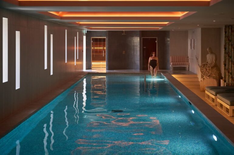 Indoor pool with person entering water.
