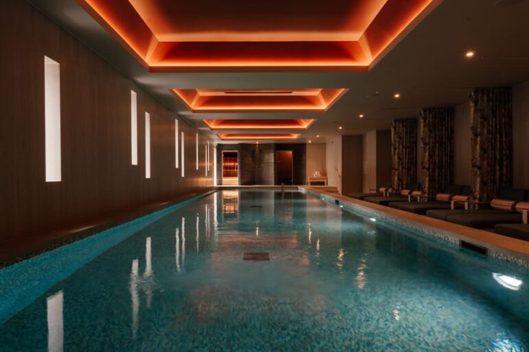 Luxurious indoor swimming pool with modern lighting.