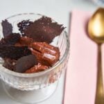 Chocolate mousse with dark chocolate shards in glass.