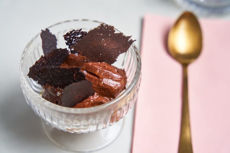 Chocolate mousse with dark chocolate shards in glass.