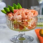 Classic prawn cocktail with avocado garnish in glass dish.