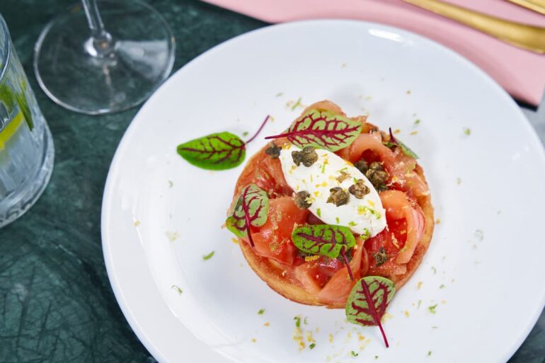 Gourmet dish with salmon and greens on plate.