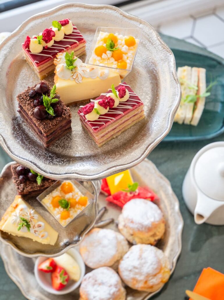 Assorted cakes and scones on a tiered stand.
