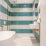 Modern bathroom with tub and blue tiles.