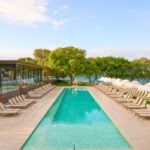 Resort pool with loungers and sea view.