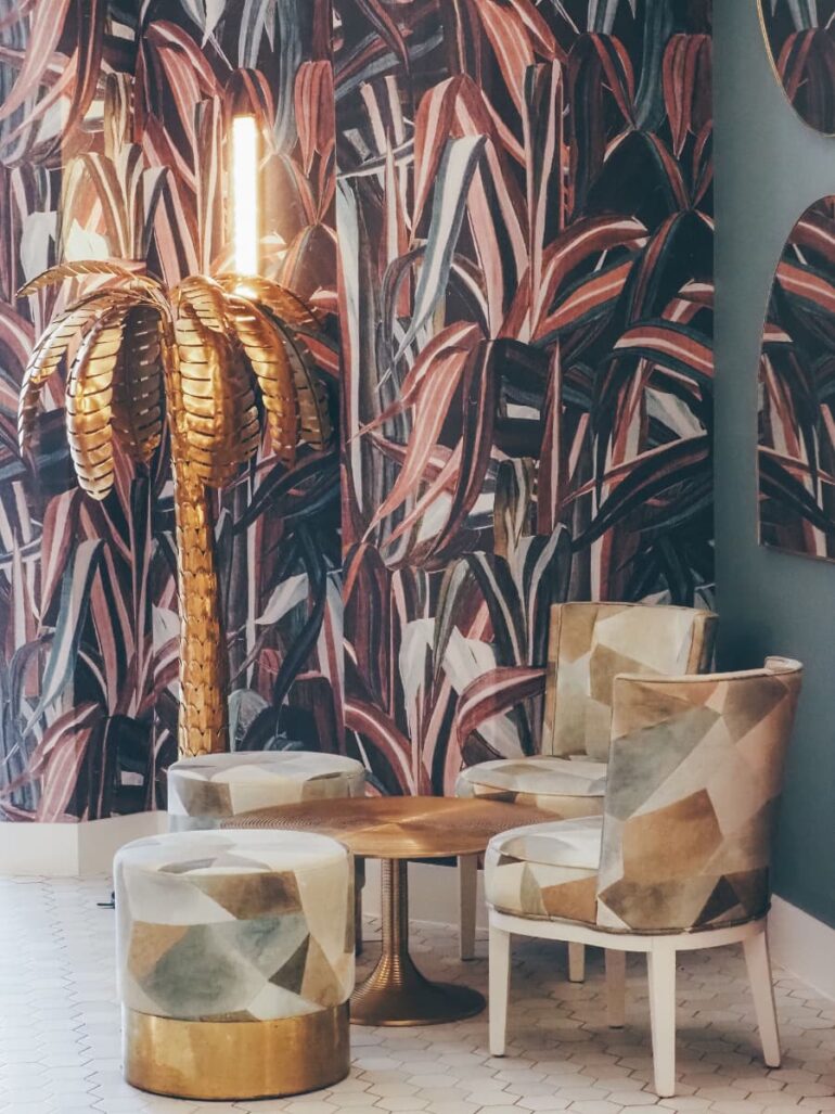 Stylish lounge with palm lamp and patterned chairs.