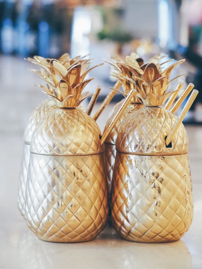 Gold pineapple-shaped drink containers on table