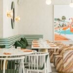 Modern restaurant interior with striped seats and artwork.