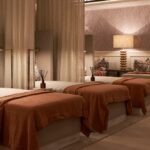 Cosy spa relaxation room with beds and lamps.