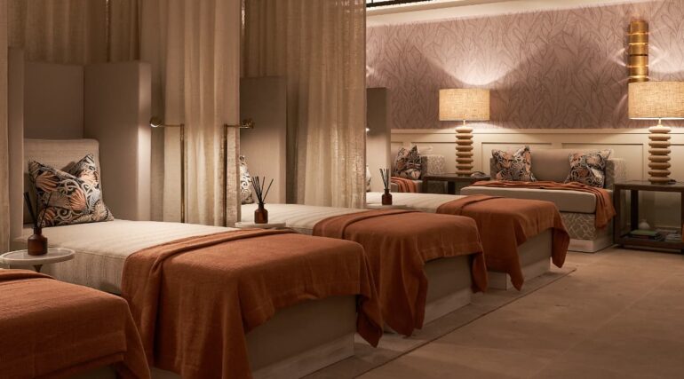 Cosy spa relaxation room with beds and lamps.