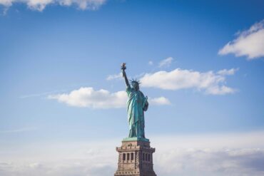 Statue of Liberty, New York under white and blue cloudy skies