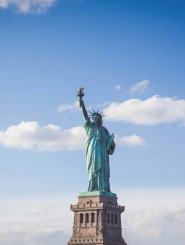 Statue of Liberty, New York under white and blue cloudy skies