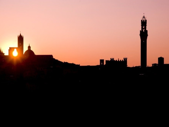 Silhouette of buildings against a colorful sunset.