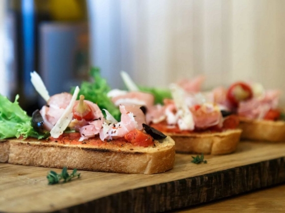 Open-faced sandwiches garnished with greens and meats.