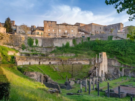 Scenic view of an ancient theater and hillside buildings.