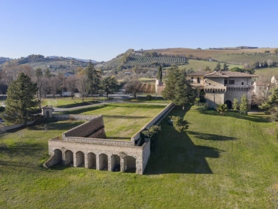 Scenic landscape featuring an old estate and lush fields.