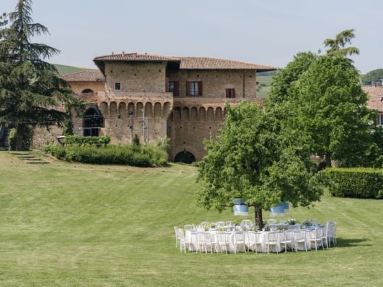A round table set for dining in a green landscape.
