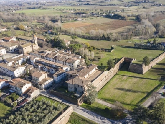 Scenic landscape featuring a village and surrounding fields.