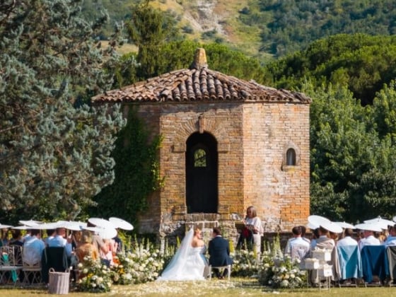 A picturesque outdoor wedding with guests seated.