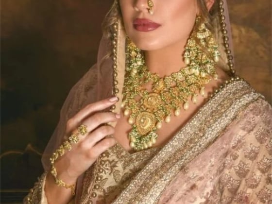 Graceful portrait of a woman adorned in gold jewelry and a pink outfit.
