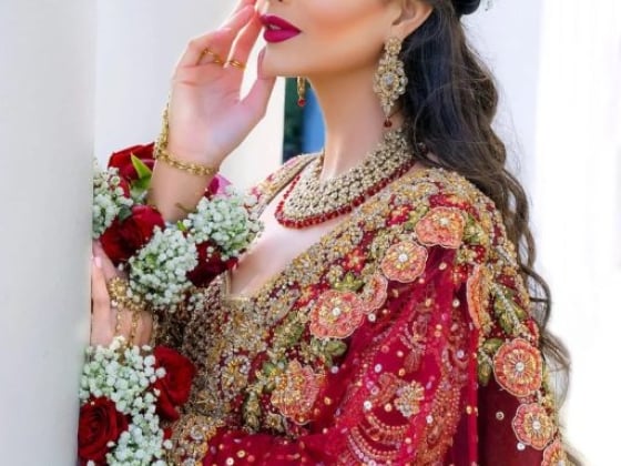 Elegant bride posing with flowers and intricate jewelry.