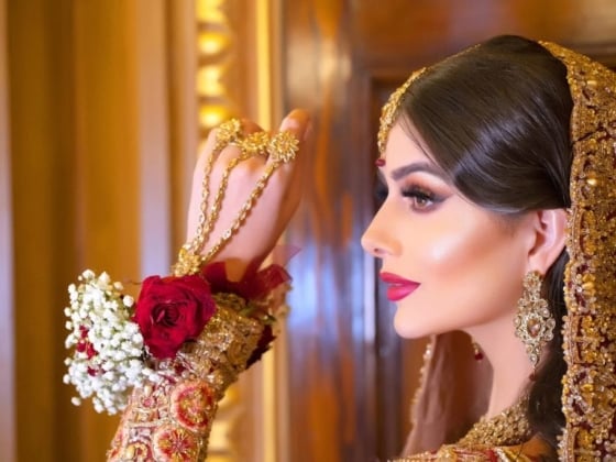 Profile of a bride showcasing ornate jewelry and flowers.