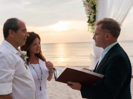 A couple exchanges vows during a beach wedding.