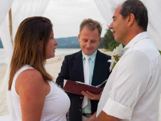 A romantic beach wedding with couple and officiant.