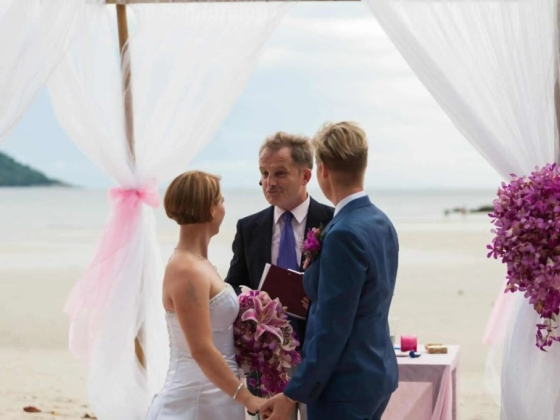 Couple exchanging vows at a scenic beach wedding.