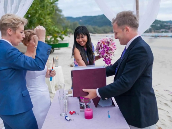 Celebrating a wedding on the beach with laughter and flowers.